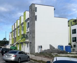 Building under construction being painted by Pinellas County painters. Image shows a crane, piles of cement blocks and portable toilets.